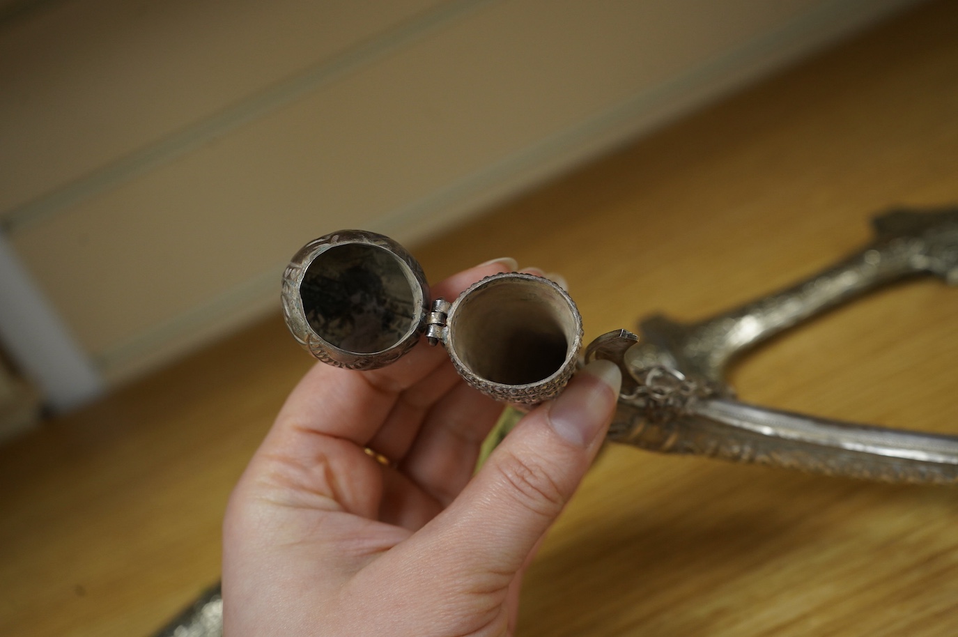 An Omani silver spice box in the form of a curved powder flask, together with a Moroccan dagger Jambiya with nickel hilt and sheath, both 20th century. Condition - fair.